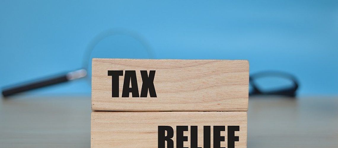 Wooden blocks with the words TAX RELIEF. Blurred background